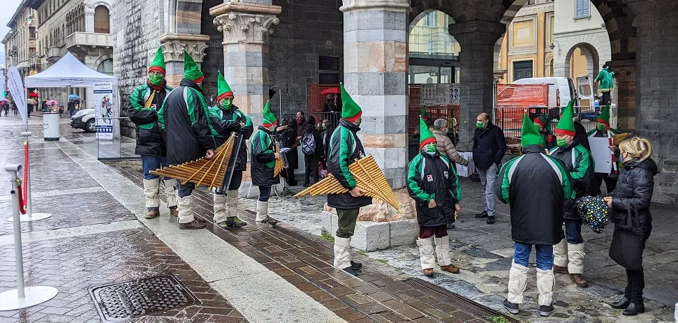 Street performers in festive costumes with pan flutes in Como