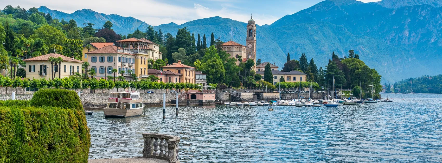 Lakeside village with boats and mountains on Lake Como