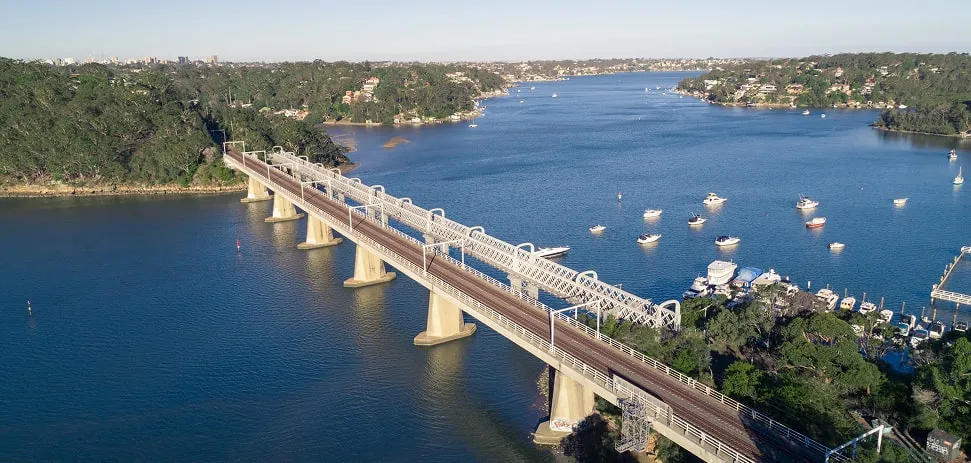 Train bridge over Lake Como with boats and scenic landscape