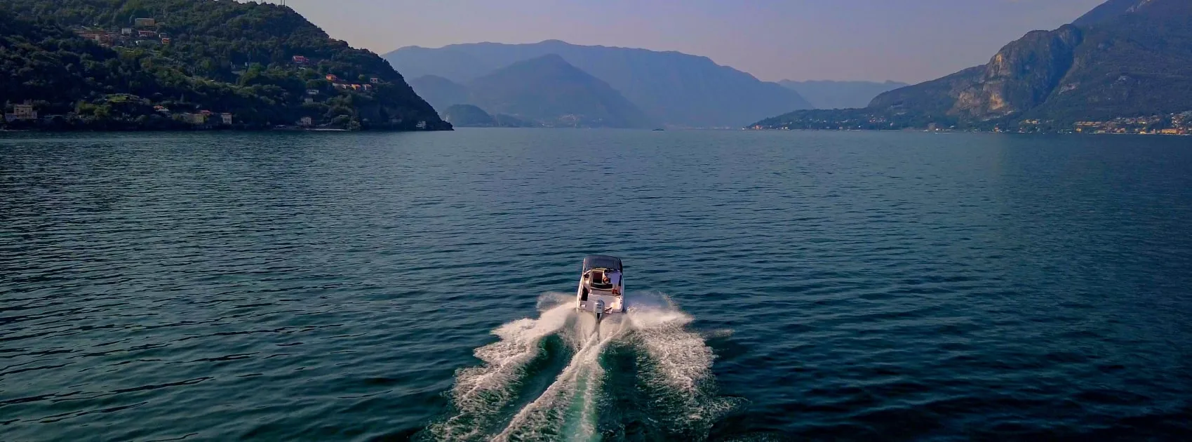 Speedboat cruising on Lake Como surrounded by mountains