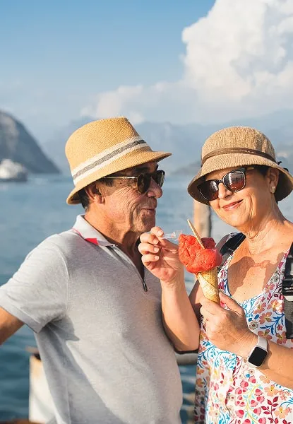 Smiling couple enjoying gelato by Lake Como